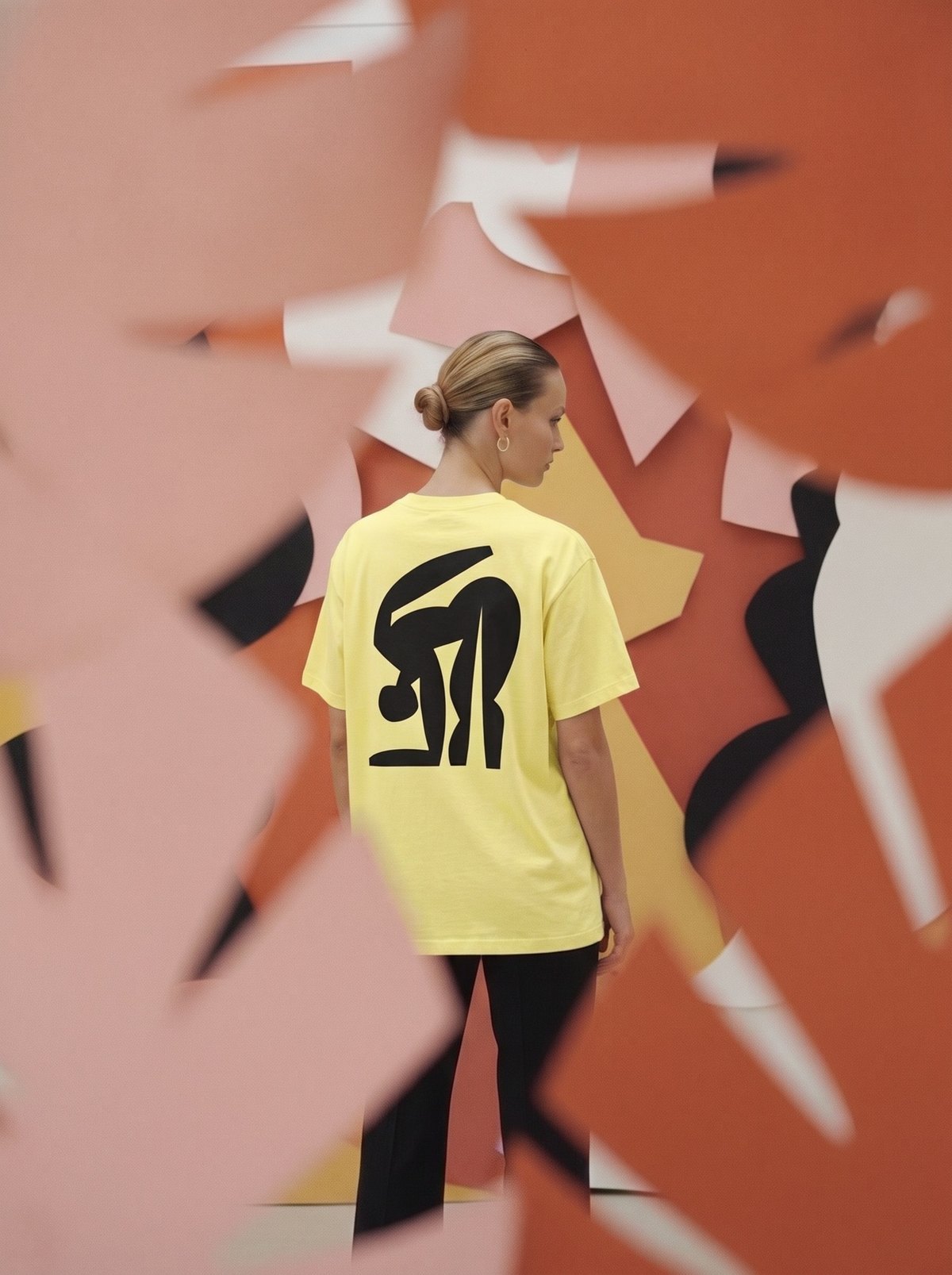 FEMME Bending tee, black ink on light yellow, framed by paper leaves