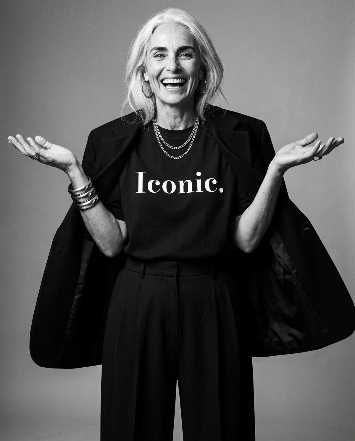 Iconic Tee worn on set, arms open, laughing
